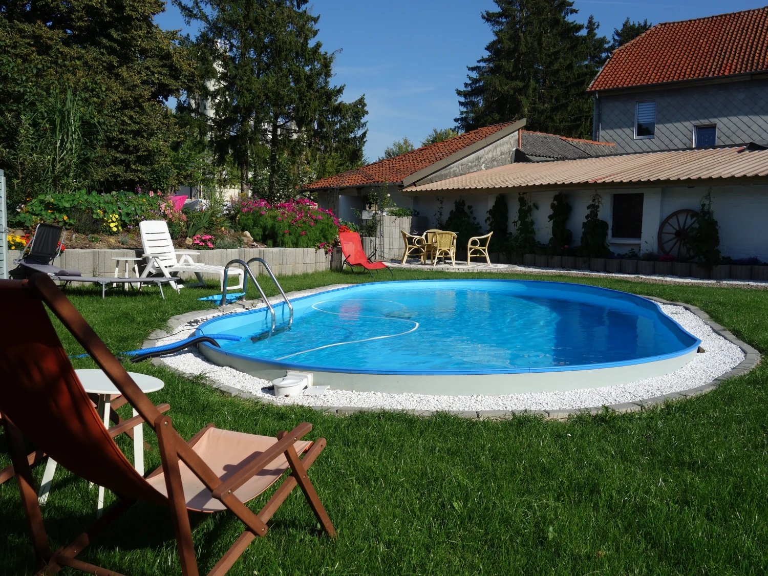 GRUPPENHAUS Außenbereich mit Pool und Stühlen